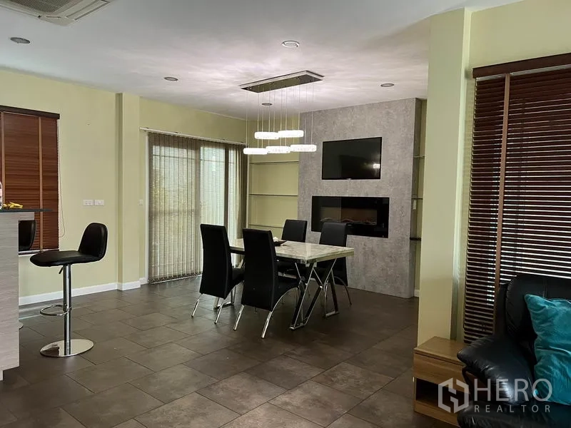 Detached House for rent in Bang Kapi, Bangkok - Dining area with marble-top table, designer pendant light and sliding glass doors.