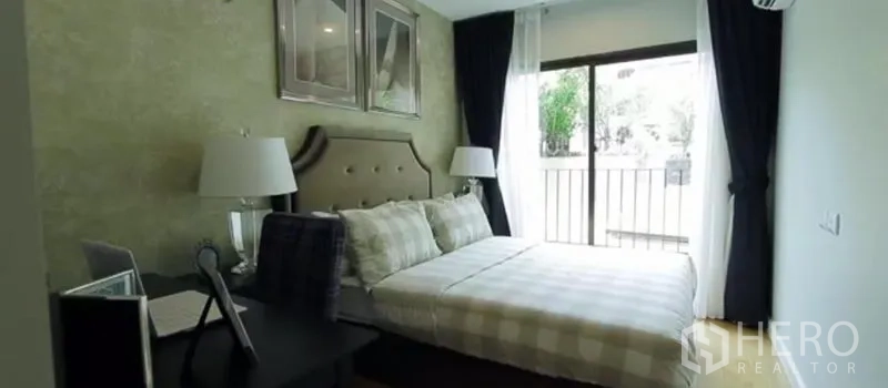 公寓 出租在Khlong Toei, Bangkok - 温馨卧室，软包床头、书桌与通向阳台的大窗。