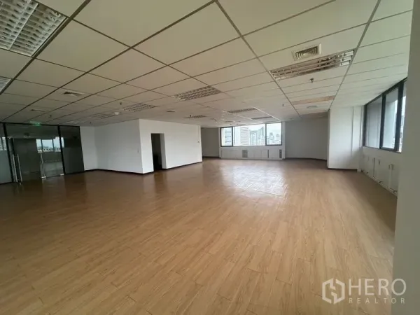 办公空间 出租在Bang Rak, Bangkok - 明亮角部办公区，长窗与白色墙面。