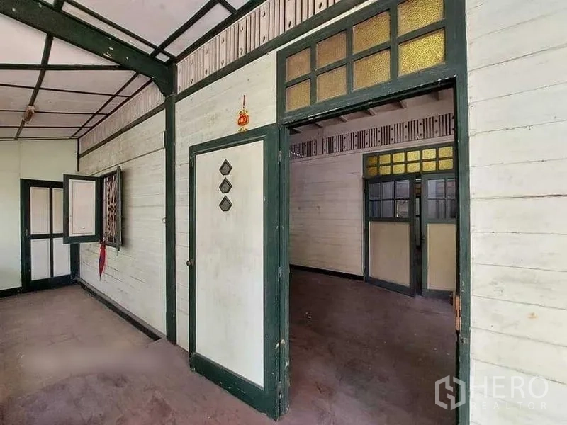 Detached House for rent in Bang Rak, Bangkok - Veranda area leading to interior rooms with original woodwork and framed windows.