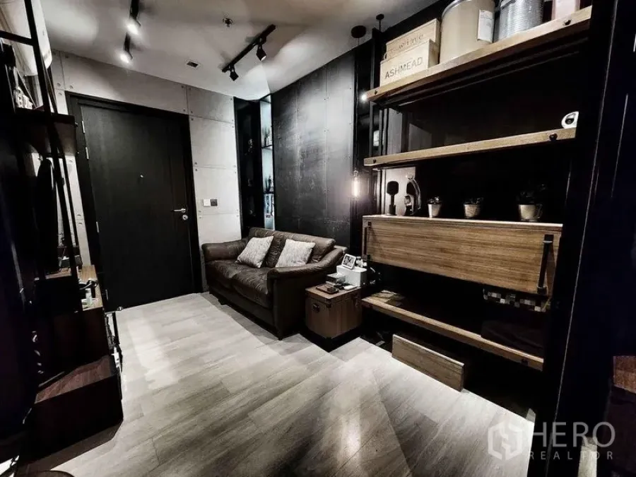 คอนโด ขายในPathum Wan, Bangkok - ภาพมุมกว้างห้องนั่งเล่น ทางเข้าห้อง ชั้นวางไม้และโซฟาหนัง