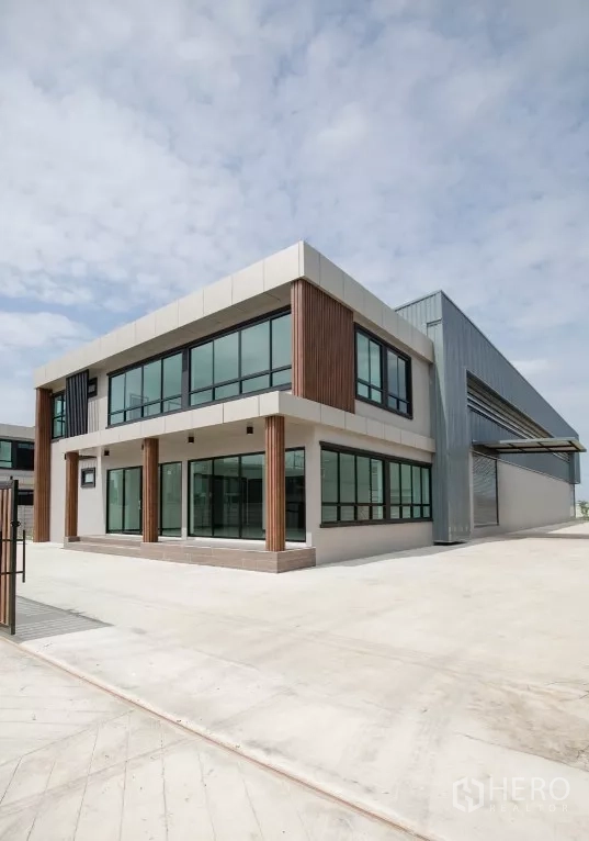 Factory for rent or sale in Bang Len, Nakhon Pathom - Corner view of new factory office next to expansive concrete yard for truck maneuvering.