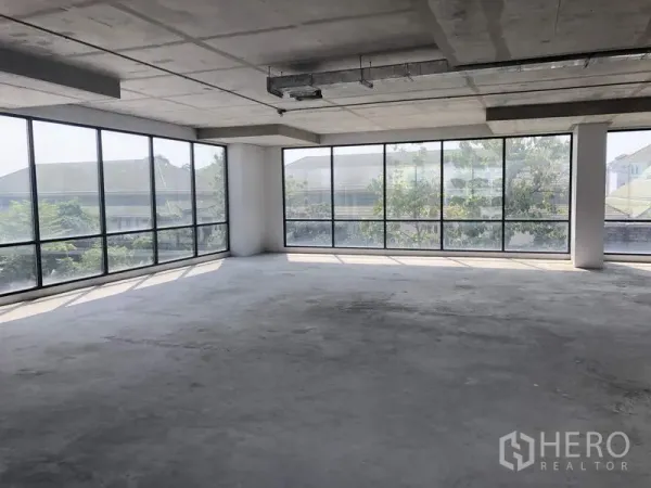 办公空间 出租在Suan Luang, Bangkok - 转角办公区配环绕落地窗与树梢景观，适合会议室或管理层空间。