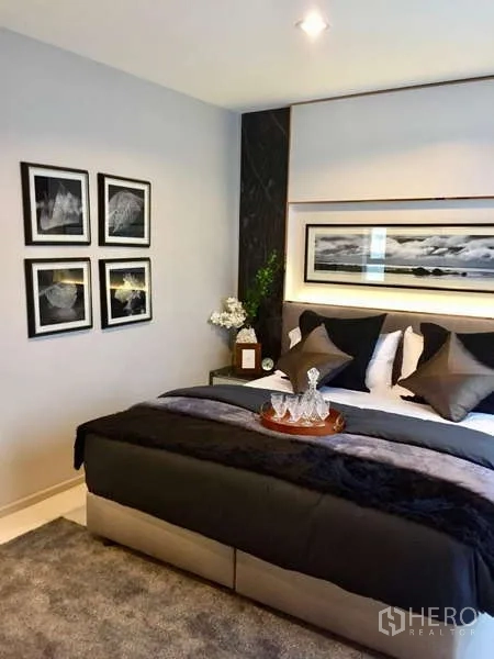 คอนโด ให้เช่าในKhlong Toei, Bangkok - ห้องนอนหลักพร้อมชุดเครื่องนอนนุ่ม ของตกแต่งหัวเตียง และกรอบรูป