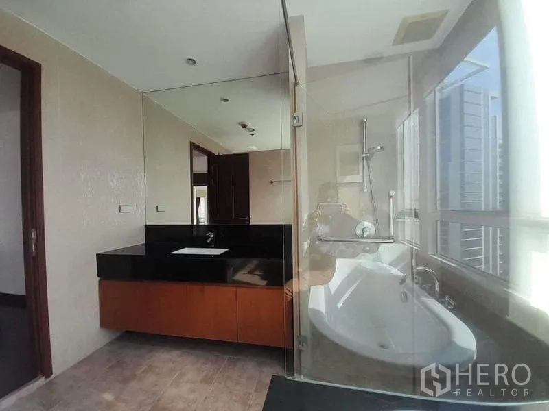 คอนโด ให้เช่าหรือขายในPathum Wan, Bangkok - ห้องน้ำสว่าง พร้อมห้องอาบน้ำกระจก อ่างอาบน้ำ และเคาน์เตอร์หินสีดำ