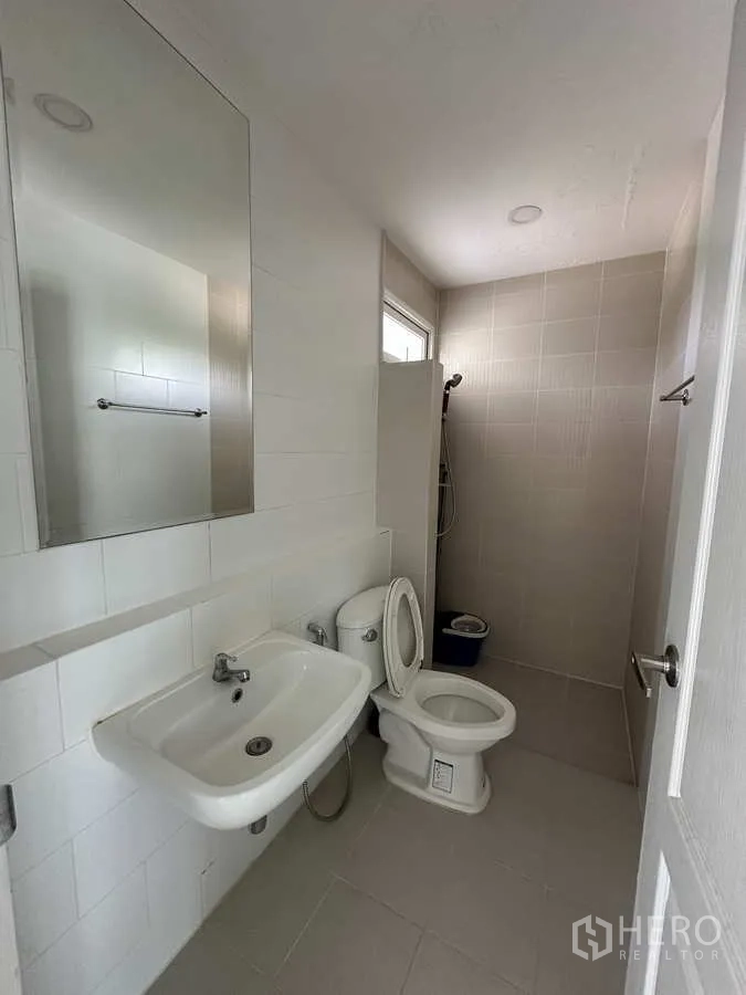 บ้าน ให้เช่าในKhlong Luang, Pathum Thani - ห้องน้ำชั้นล่างพร้อมโซนอาบน้ำ โถสุขภัณฑ์ และกระจกเงา