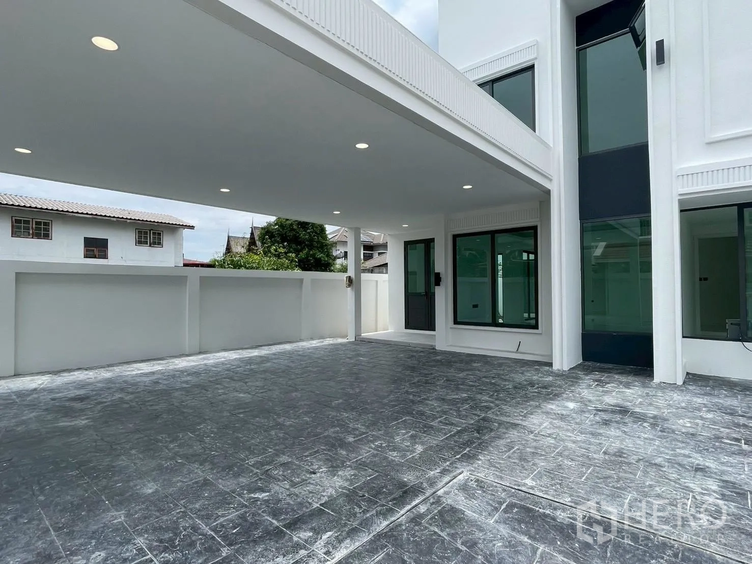 Detached House for sale in Chatuchak, Bangkok - Modern two-storey white detached house exterior with carport and boundary wall.