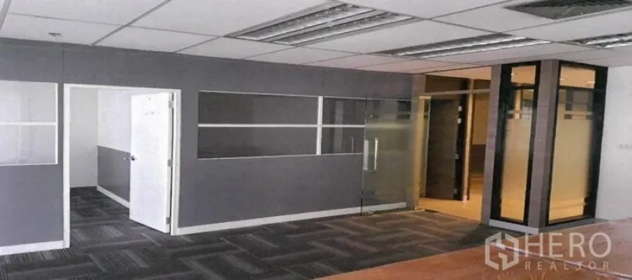Office Space for rent in Bang Rak, Bangkok - Partitioned office interior with carpet tiles, half-glass walls and drop ceiling lighting.