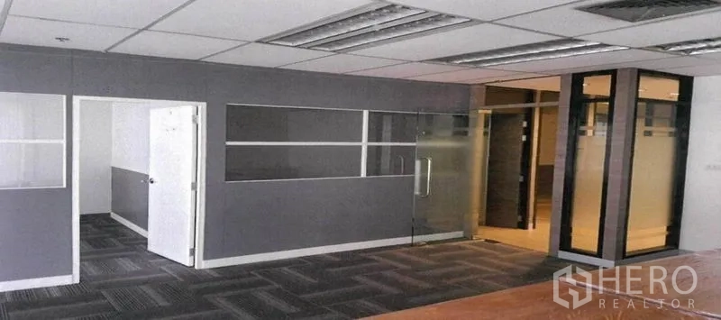 Office Space for rent in Bang Rak, Bangkok - Partitioned office interior with carpet tiles, half-glass walls and drop ceiling lighting.