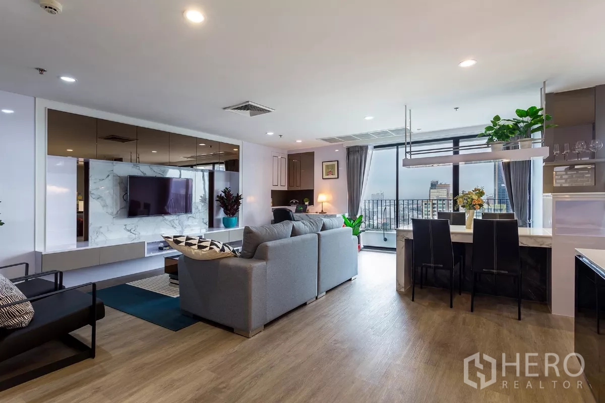 Condominium for rent or sale in Watthana, Bangkok - Open-plan living and dining area of a Bangkok condo with marble TV wall, balcony and skyline views near BTS Thonglor.