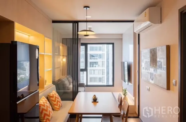 คอนโด ให้เช่าในChatuchak, Bangkok - มุมทานอาหารสว่างพร้อมเบาะนั่ง โคมแขวน และหน้าต่างวิวเมือง ข้างฉากกั้นกระจก