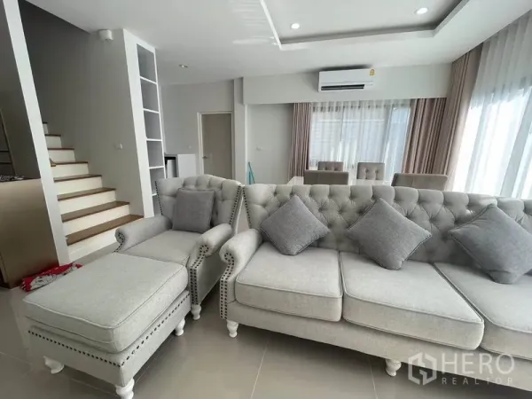 บ้าน ให้เช่าในPrawet, Bangkok - ห้องนั่งเล่นโปร่งสว่าง โซฟาสีเทาและบันไดสไตล์ร่วมสมัย