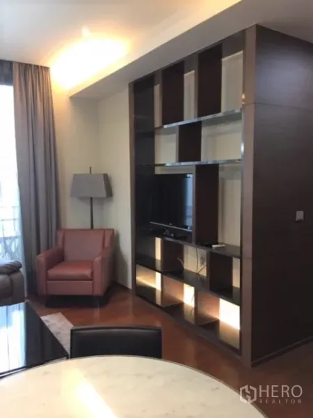 คอนโด ให้เช่าหรือขายในWatthana, Bangkok - ผนังชั้นวางบิลท์อินพร้อมทีวีและไฟส่องสว่างข้างเก้าอี้พักผ่อน