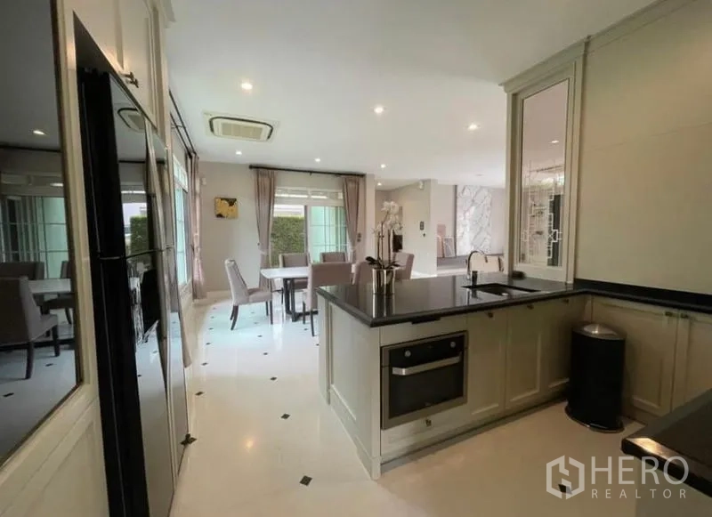 Detached House for rent in Bang Phli, Samut Prakan - Open-plan Western kitchen and dining area with island, oven and garden view.