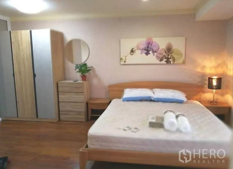 คอนโด ให้เช่าในKhlong Toei, Bangkok - ห้องนอนใหญ่เตียงไม้ แสงไฟอบอุ่น พร้อมตู้เสื้อผ้า
