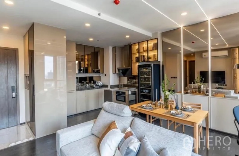 Condominium for sale in Watthana, Bangkok - Modern kitchen with glossy cabinets, built-in appliances and a four-seat dining table