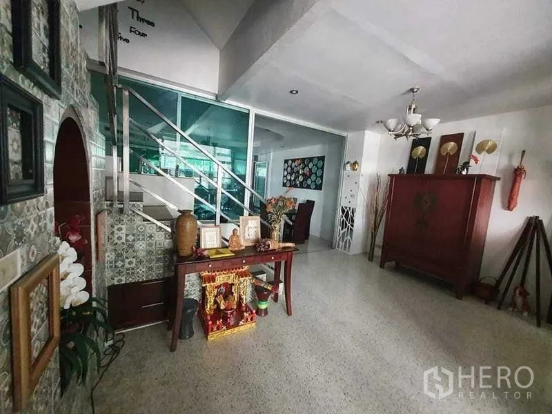 Townhouse for rent or sale in Bang Kho Laem, Bangkok - Entry foyer with decorative console and staircase with glass-and-steel railing.
