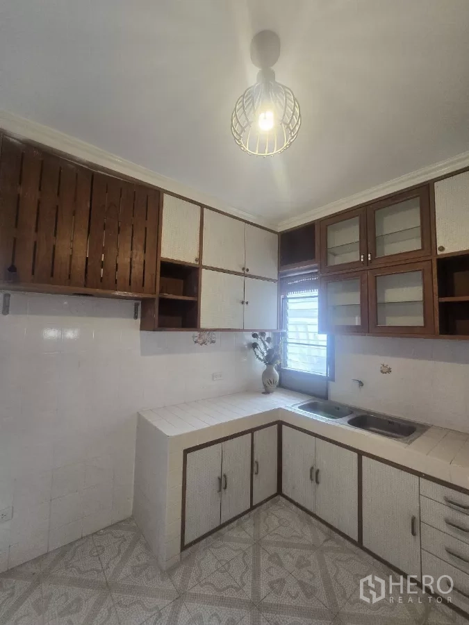 独立式住宅 出租在Phra Khanong, Bangkok - L形厨房，瓷砖台面、上柜与窗户