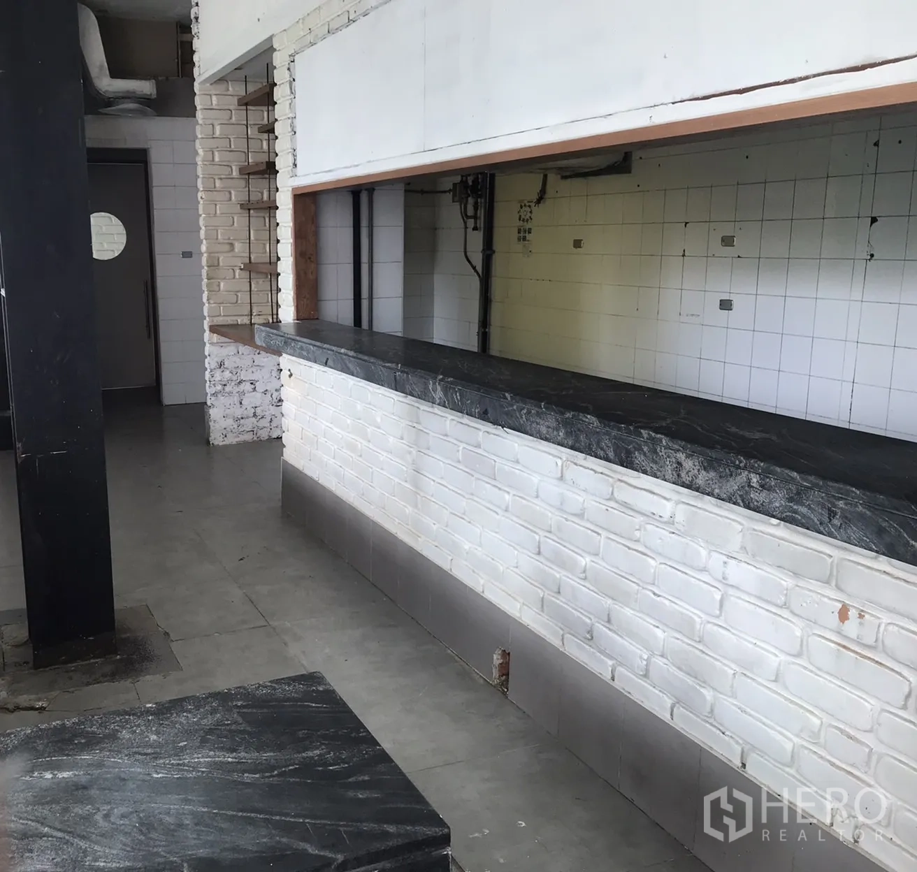 พื้นที่ขายปลีก ให้เช่าในKhlong Toei, Bangkok - เคาน์เตอร์บริการยาว ท็อปหินสีเข้ม ฐานอิฐขาวภายในพื้นที่ค้าปลีก