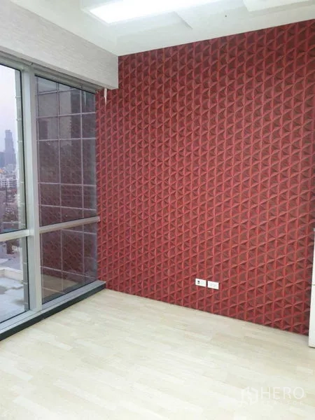 Office Space for rent - Private room with red textured accent wall and full-height window overlooking the city.