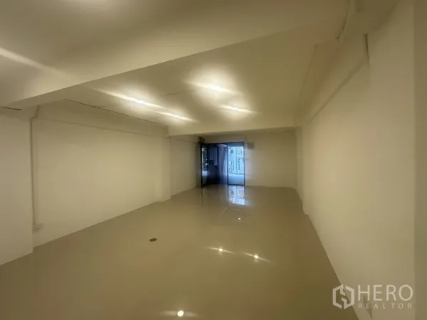 零售空间 出租 - 从室内望向临街玻璃门的长形店铺空间。