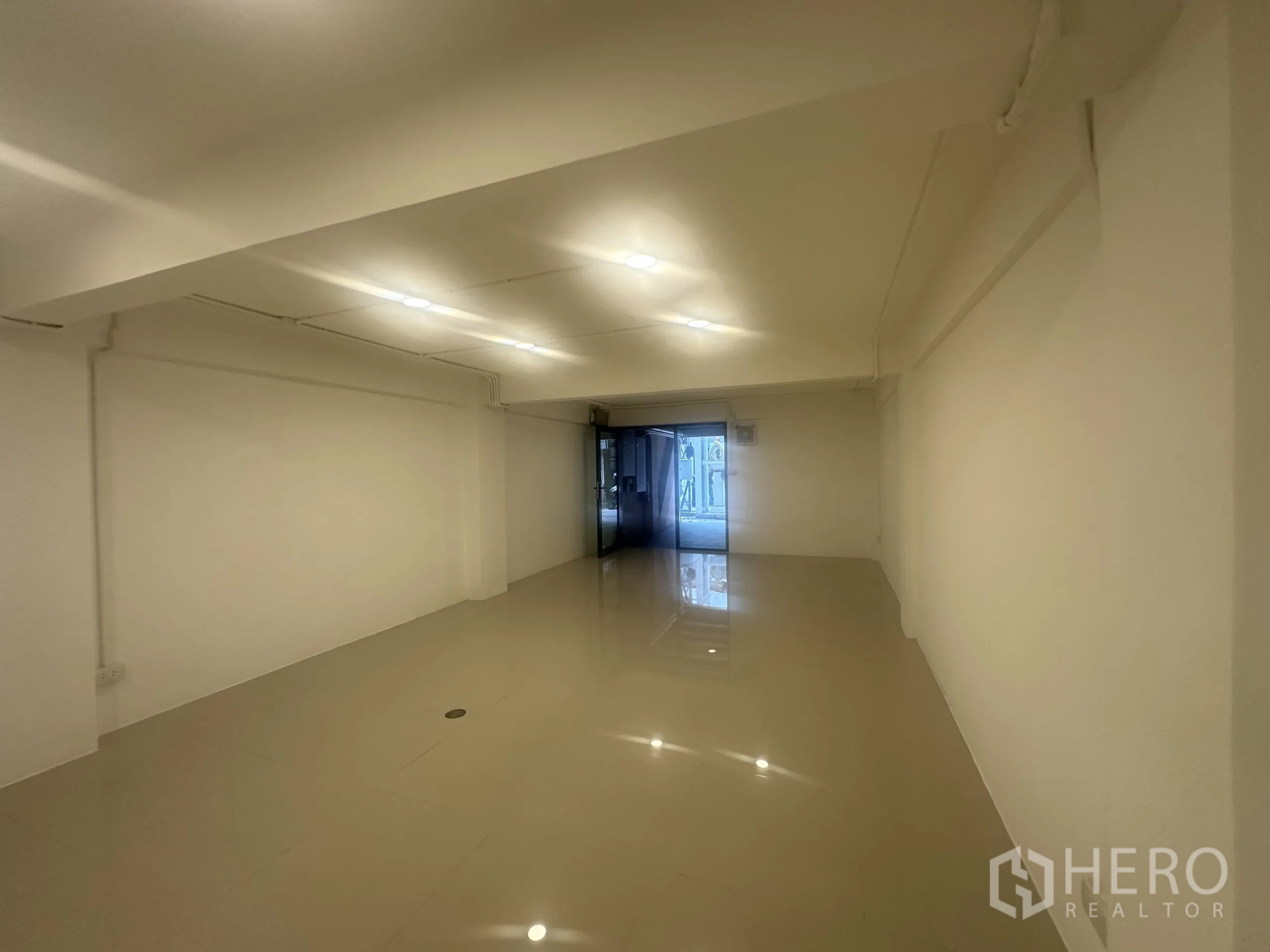 零售空间 出租 - 从室内望向临街玻璃门的长形店铺空间。