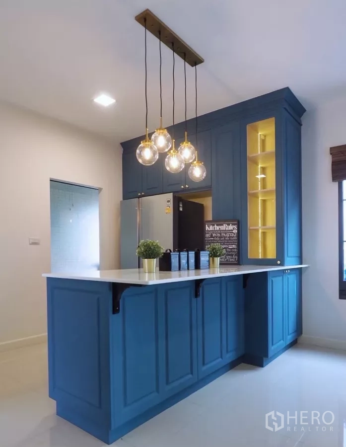 Detached House for sale in Bang Phli, Samut Prakan - Close-up of blue pantry and breakfast bar with globe pendant lights and built-in display shelves.