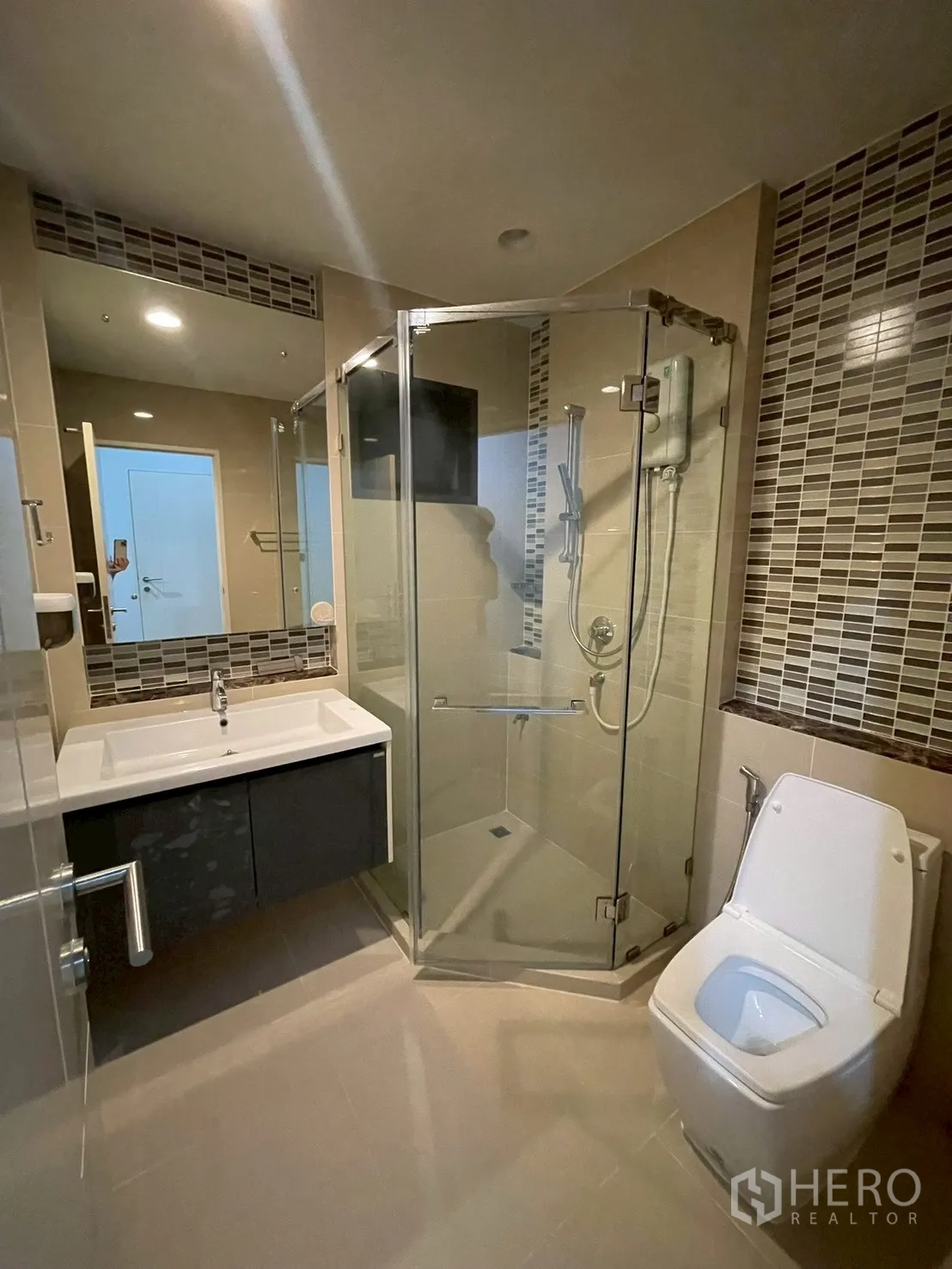 Detached House for rent in Bang Kapi, Bangkok - Bathroom with corner glass shower, vanity, and patterned tile accents.