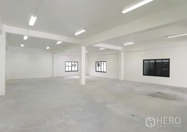 คลังสินค้า ให้เช่าในSamut Prakan - พื้นที่โกดังโล่งกว้าง ผนังสีขาว มีเสา หน้าต่าง และไฟยาวสว่าง เหมาะเก็บสินค้า/ผลิต