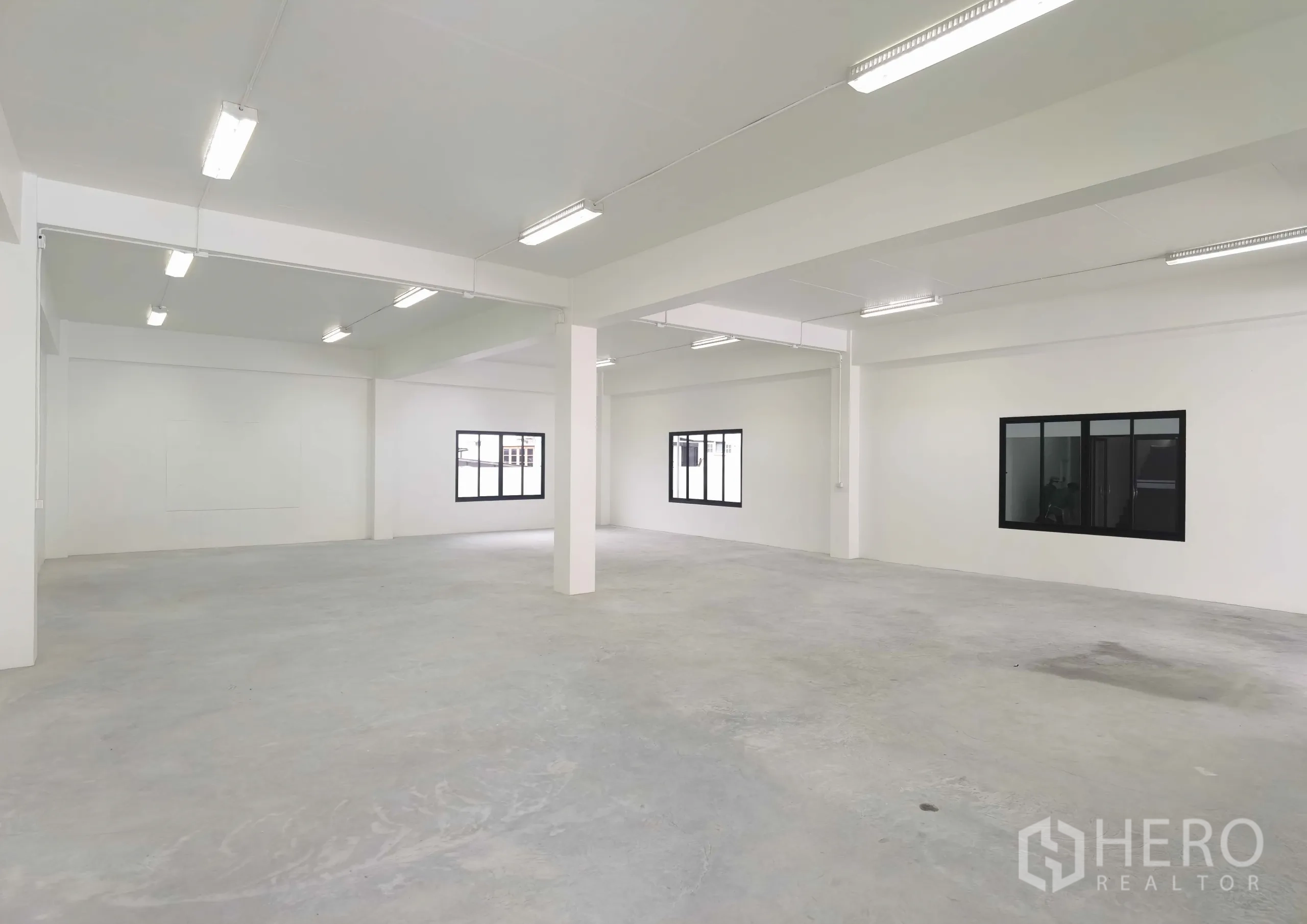 คลังสินค้า ให้เช่าในSamut Prakan - พื้นที่โกดังโล่งกว้าง ผนังสีขาว มีเสา หน้าต่าง และไฟยาวสว่าง เหมาะเก็บสินค้า/ผลิต