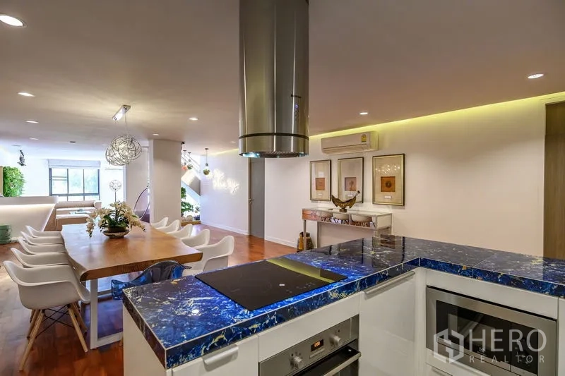 Condominium for rent in Pathum Wan, Bangkok - Open kitchen with striking blue marble counters facing a large dining area.
