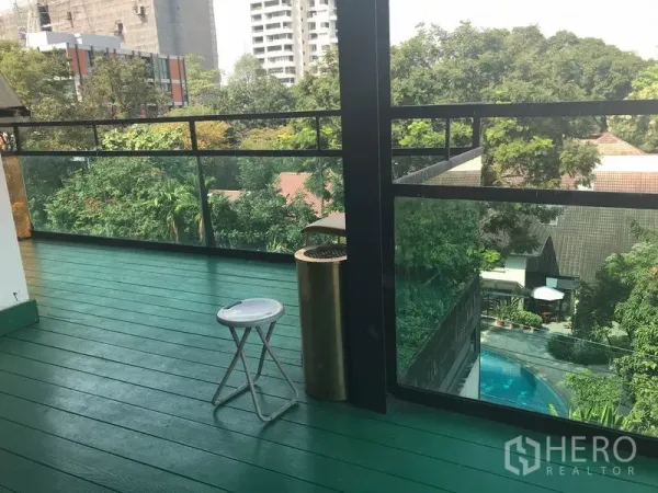 พื้นที่ขายปลีก ให้เช่าในWatthana, Bangkok - ระเบียงกว้าง พื้นไม้สีเขียว ราวกระจก และวิวต้นไม้ใจกลางเมือง