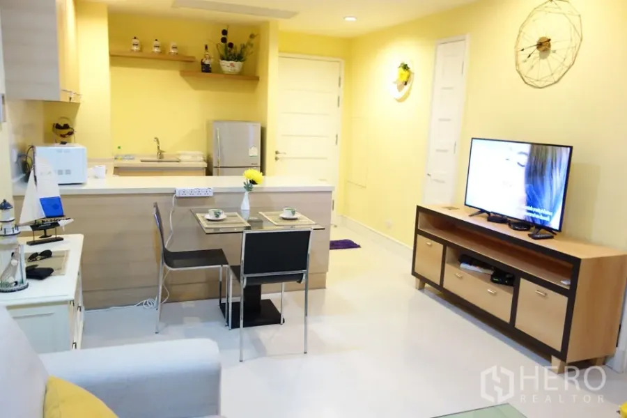 คอนโด ให้เช่าในKhlong Toei, Bangkok - ครัวเปิดพร้อมเคาน์เตอร์บาร์ มุมทานอาหารสำหรับสองที่ และชั้นวางทีวี