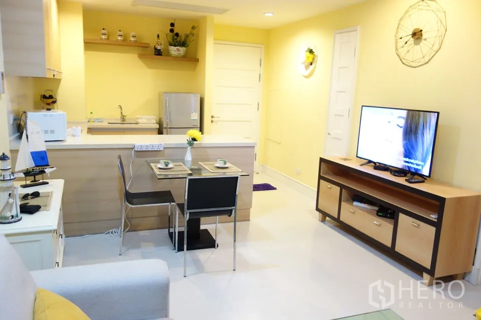 คอนโด ให้เช่าในKhlong Toei, Bangkok - ครัวเปิดพร้อมเคาน์เตอร์บาร์ มุมทานอาหารสำหรับสองที่ และชั้นวางทีวี