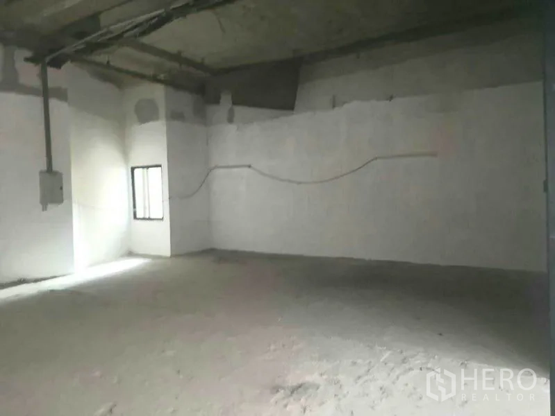 零售空间 出租在Khlong Toei, Bangkok - 未完成的商铺空间，白色抹灰墙、外露天花和小窗。