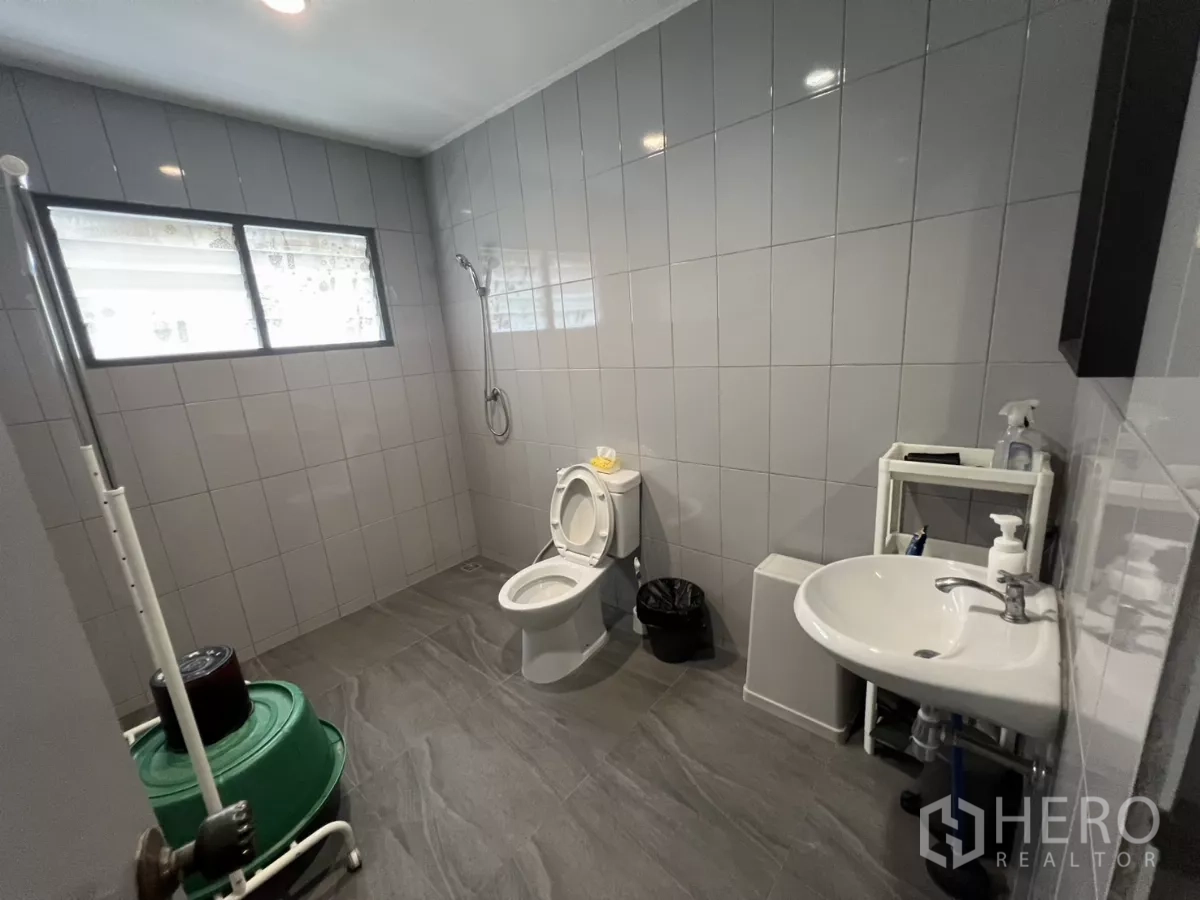 零售空间 出租在Watthana, Bangkok - 宽敞瓷砖卫生间，带窗、花洒、洗手盆与马桶。