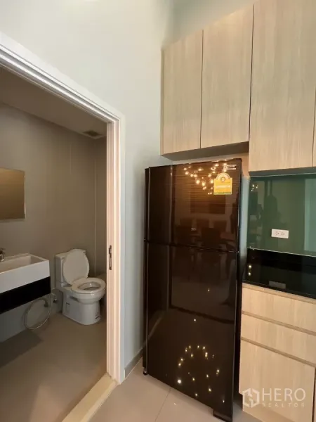 ทาวน์เฮาส์ ให้เช่าในSuan Luang, Bangkok - มุมครัวที่มีตู้เย็นขนาดใหญ่ติดกับทางเข้าห้องน้ำแขก