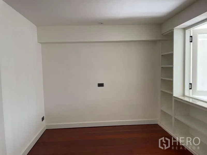 สำนักงานที่บ้าน ให้เช่าในWatthana, Bangkok - ห้องพร้อมชั้นเก็บของบิลท์อิน ผนังสีขาวและพื้นไม้.