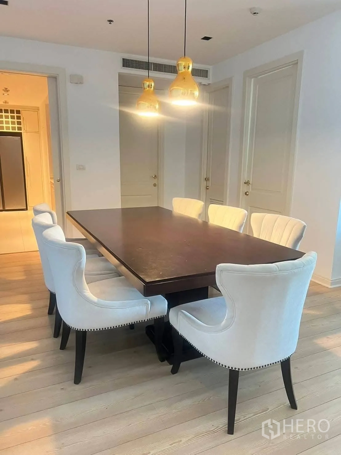 คอนโด for rent in Pathum Wan, Bangkok - ภาพระยะใกล้โต๊ะอาหารพร้อมเก้าอี้บุนวมและโคมไฟแขวนคู่