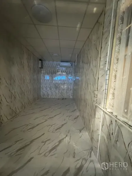 零售空间 出租在Watthana, Bangkok - 18㎡狭长室内空间，大理石纹地面与墙面，吊顶照明与空调。