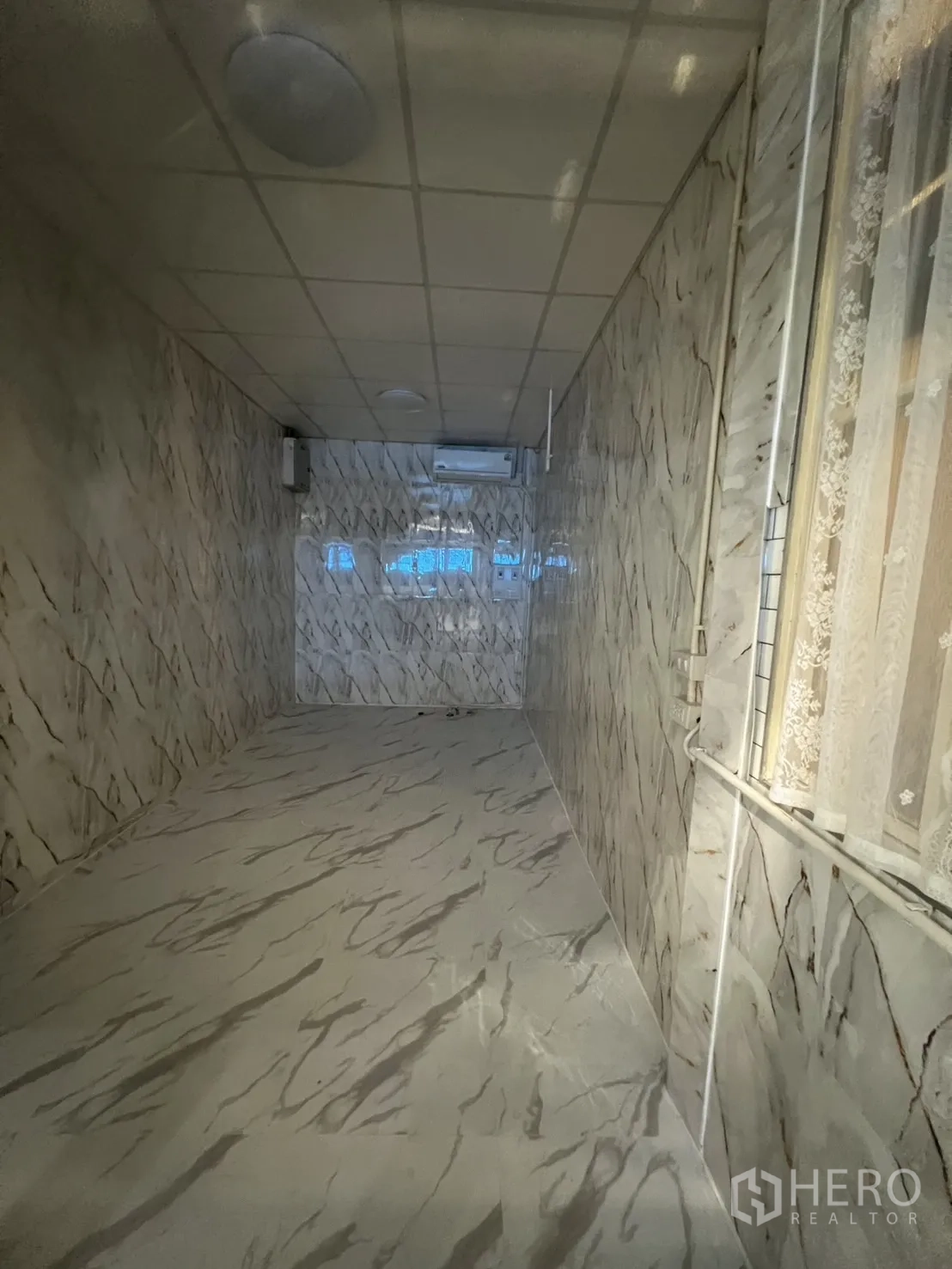 零售空间 出租在Watthana, Bangkok - 18㎡狭长室内空间，大理石纹地面与墙面，吊顶照明与空调。