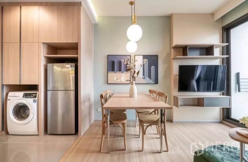 คอนโด ให้เช่าในChatuchak, Bangkok - มุมทานอาหารพร้อมโคมไฟทรงกลม งานศิลป์ และผนังทีวีติดกับประตูระเบียง.