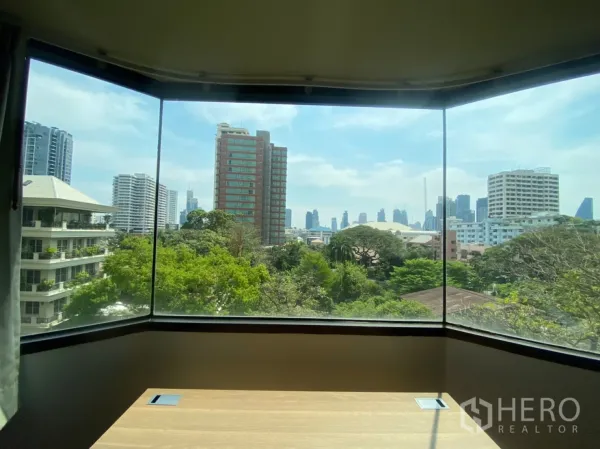 Condominium for rent in Watthana, Bangkok - Bay window with panoramic city skyline and treetop views in the Sukhumvit area.