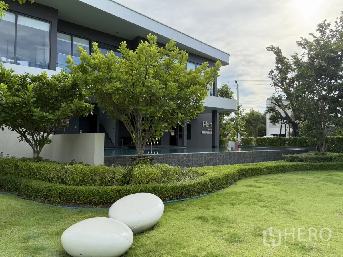 Townhouse for rent or sale in Bang Phli, Samut Prakan - Clubhouse exterior with landscaped lawns, trees and poolside.