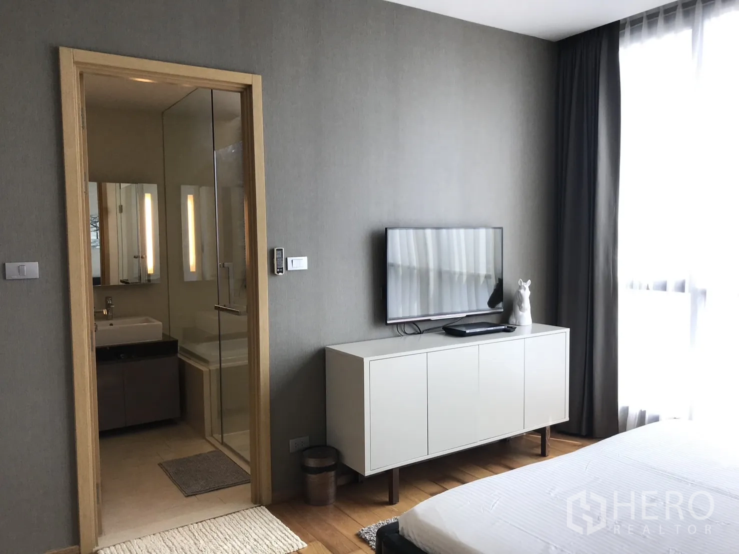 Condominium for rent in Watthana, Bangkok - Bathroom with bathtub positioned under a window fitted with blinds.
