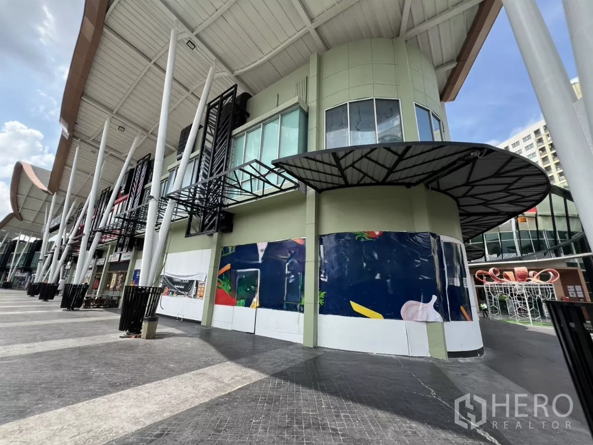 พื้นที่ขายปลีก ให้เช่า - หน้าร้านมุมอาคารทรงโค้ง ในพลาซ่าสมัยใหม่ มีเสาสูงและทางเดินมีหลังคา