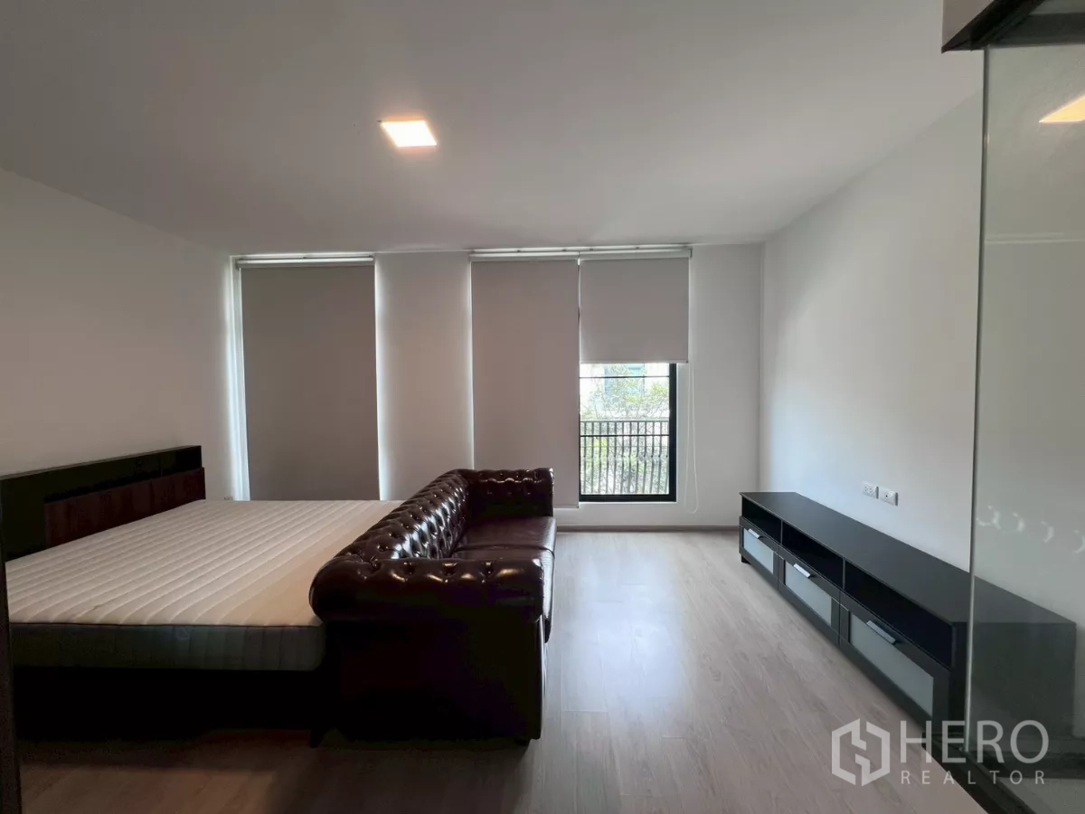ทาวน์เฮาส์ ให้เช่าในBang Phli, Samut Prakan - ห้องนอนใหญ่ เตียงขนาดใหญ่ โซฟาหนัง และหน้าต่างระเบียงสูง