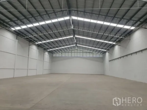 货栈 出租在Khlong Luang, Pathum Thani - 仓库内部空间开阔，钢桁架高屋顶与采光带，混凝土地面。