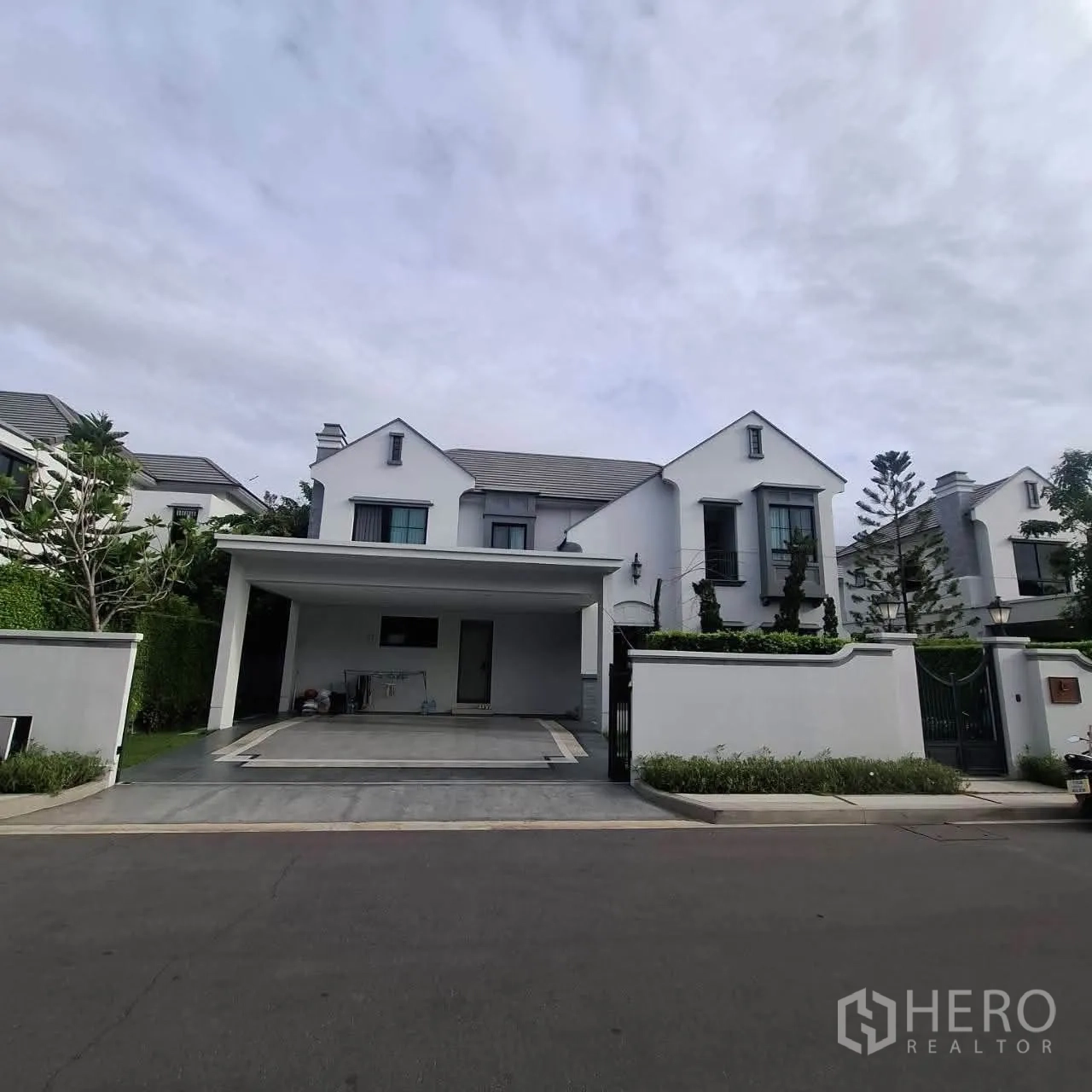 独栋房屋 for rent in Saphan Sung, Bangkok - 现代白色独栋外立面，带入户大门与有顶车棚。