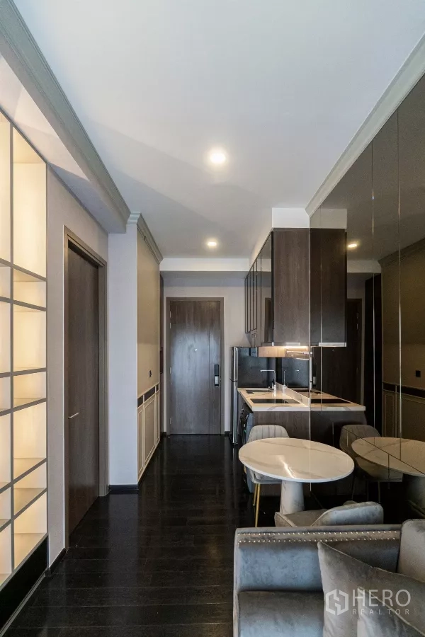 公寓 出租在Watthana, Bangkok - 入口走廊与紧凑厨房，镜面柜与用餐角，现代曼谷公寓。